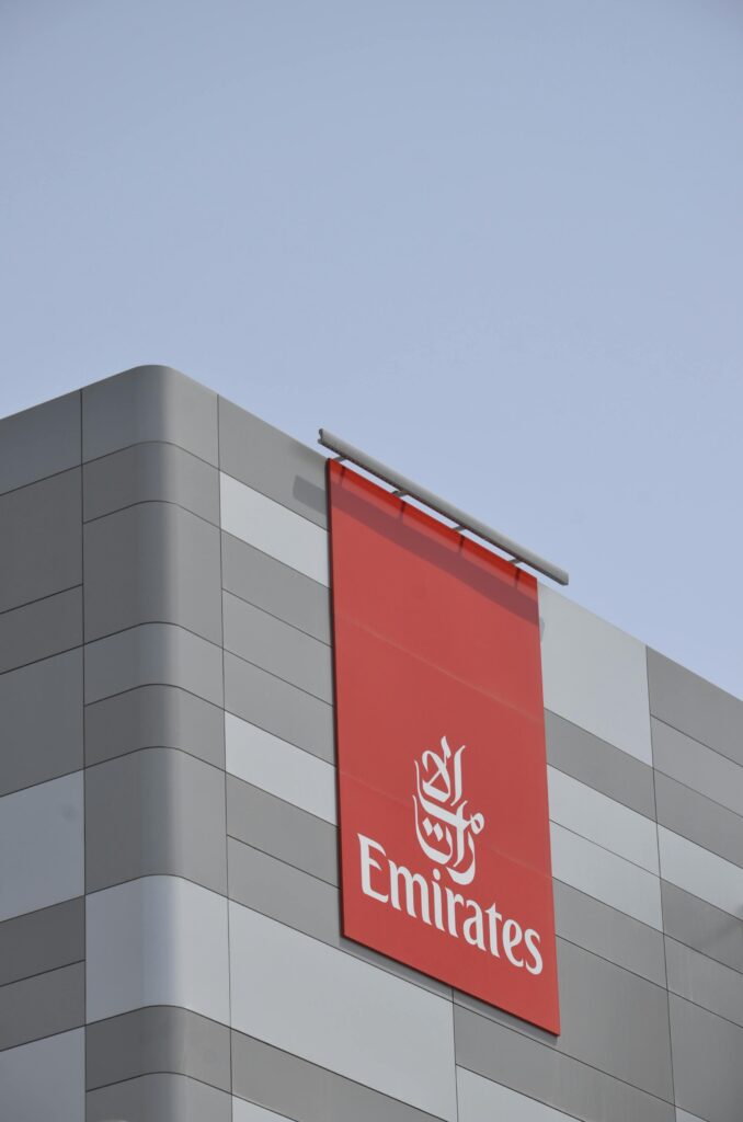 A striking low angle shot of a modern building with Emirates branding in Dubai.